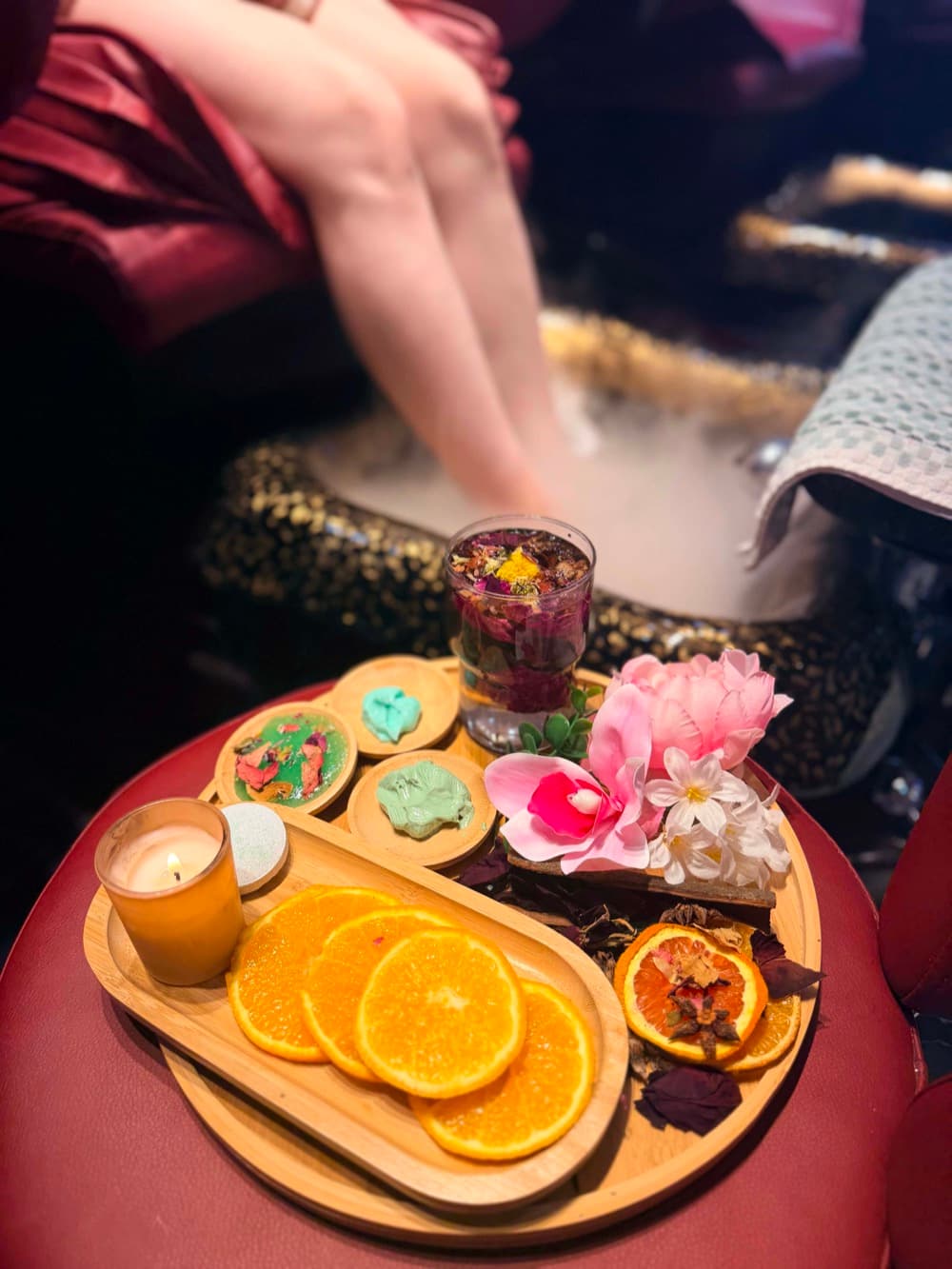 Spa treatment with a candle, citrus, and floral tray
